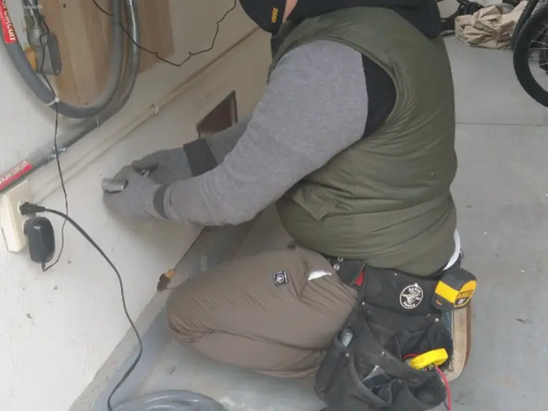 Electrician performing outlet wiring in a Gibson garage